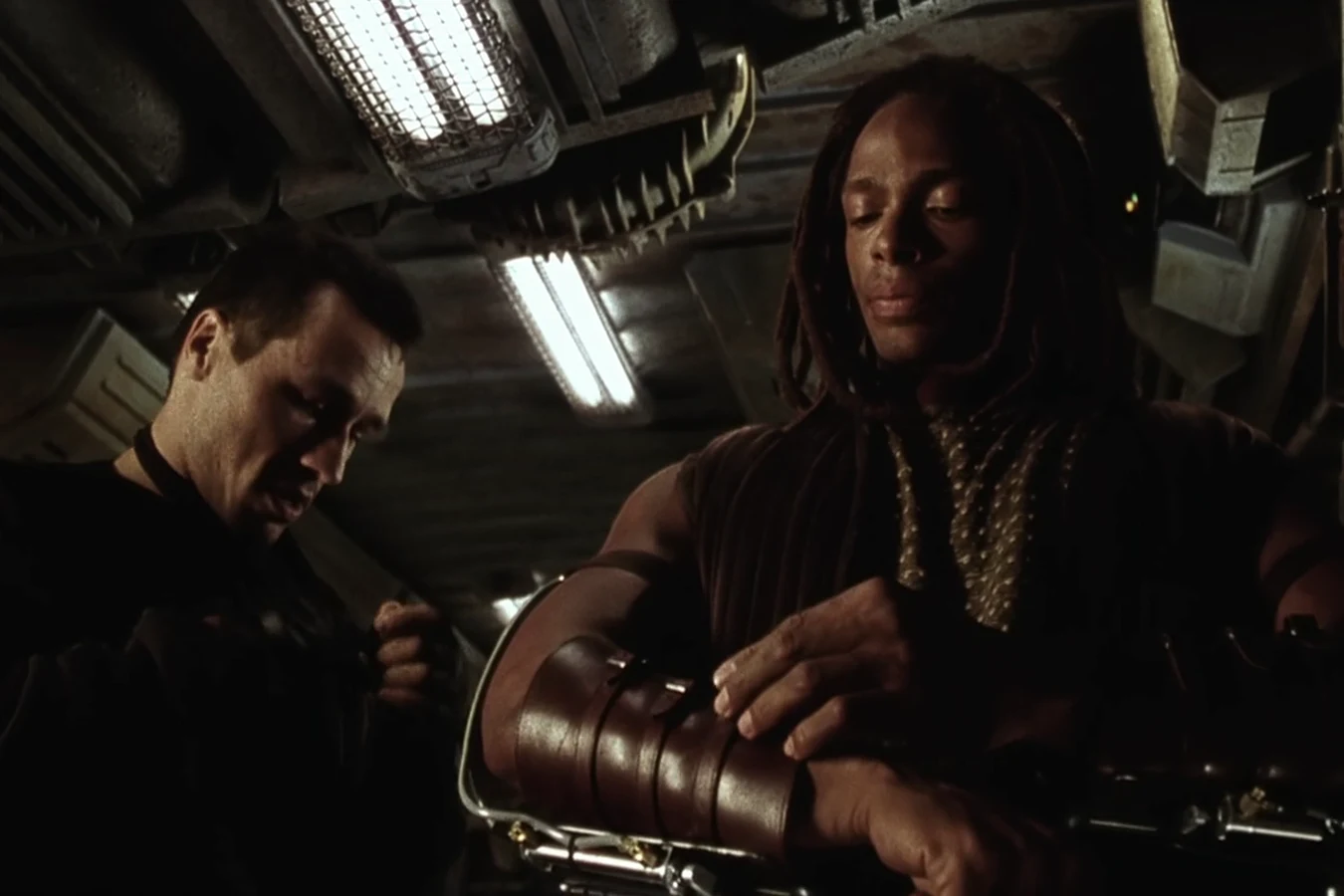 Christie strapping his gun rigs onto his forearms aboard the Betty as Elgyn helps him