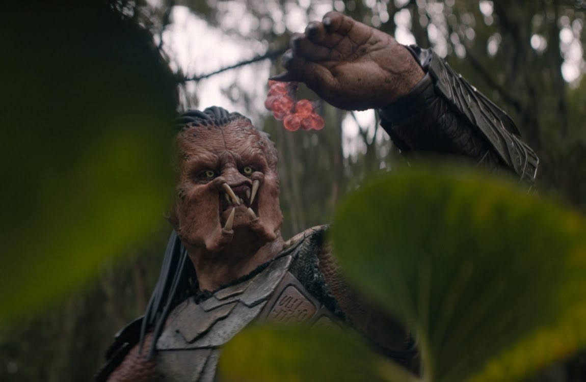 Dek holding an exploding worm in Predator: Badlands