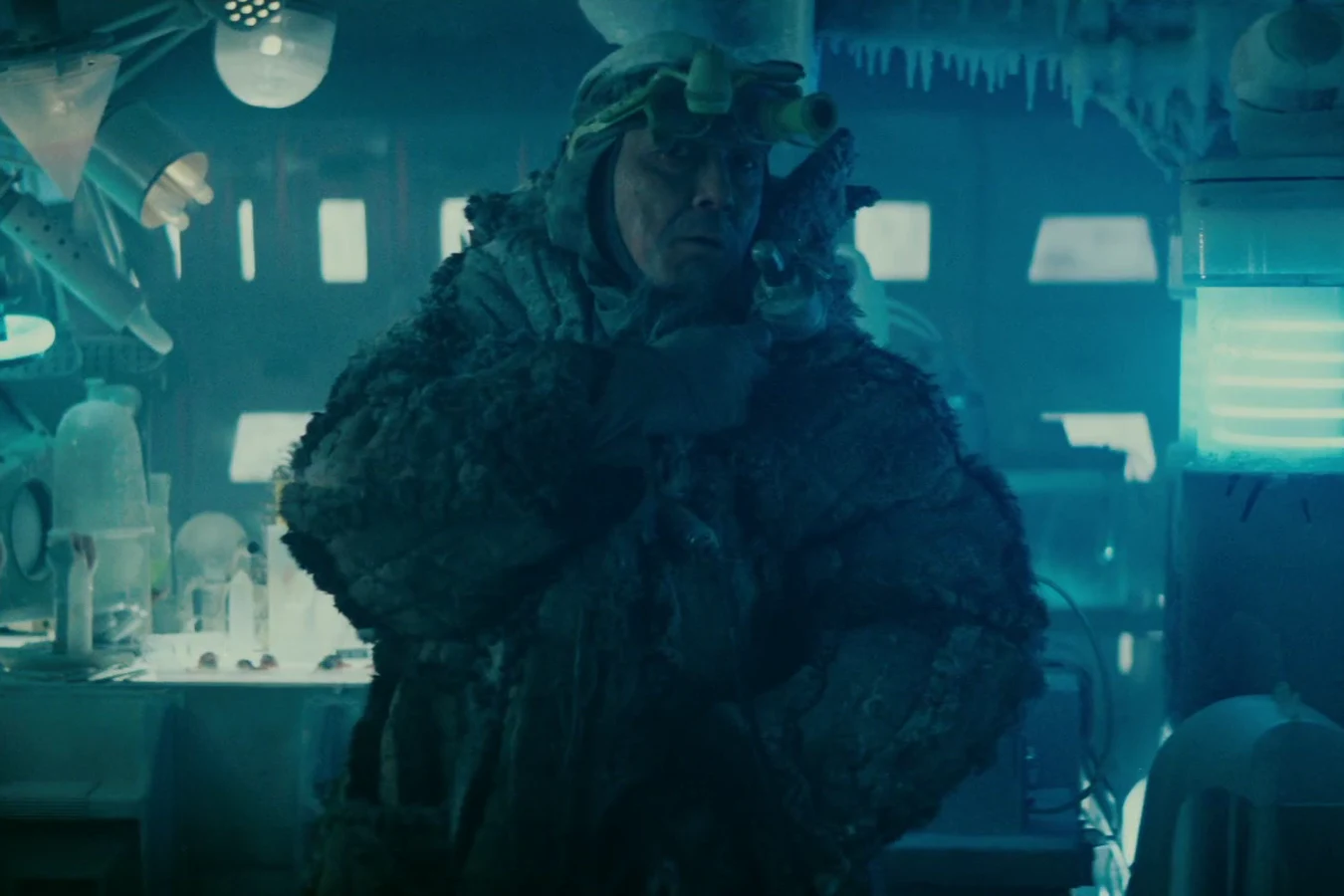 Chew in a heavy fur coat and goggles standing among the frosted equipment of his eye lab in Blade Runner