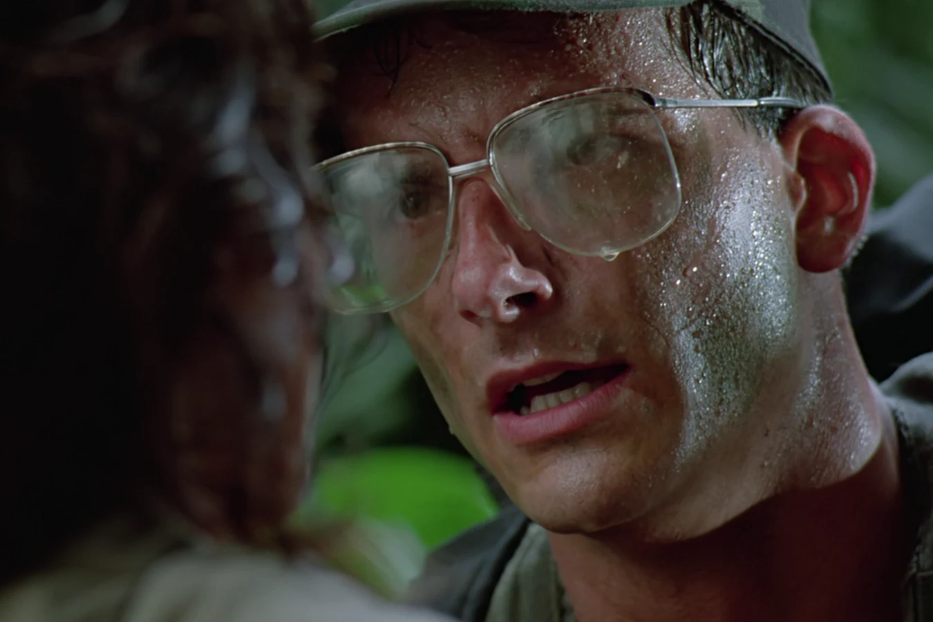 Close-up of Rick Hawkins holding Anna at gunpoint after catching her in the jungle in Predator
