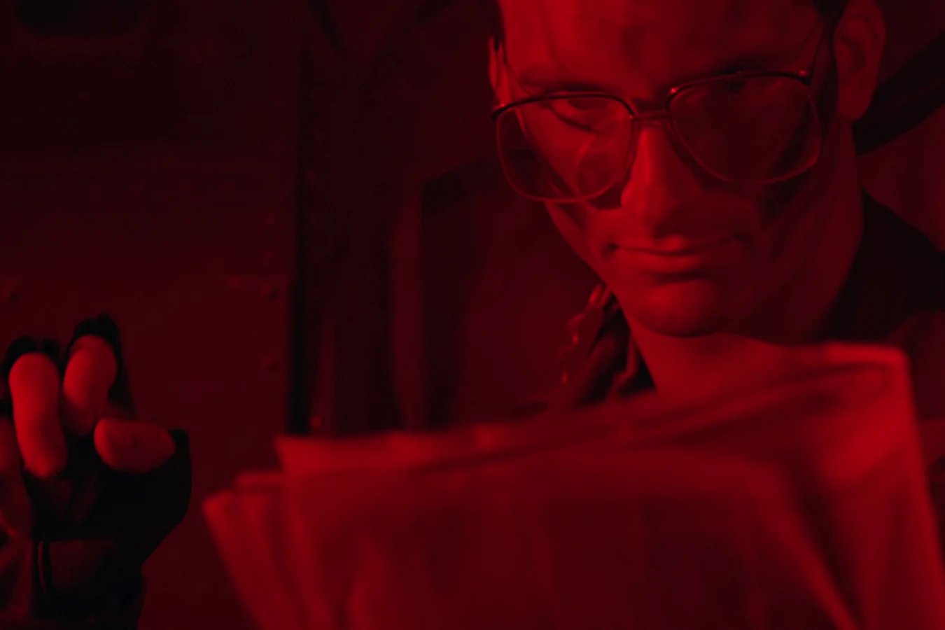 Rick Hawkins lit by the red cabin light of the helicopter flying the team into Val Verde in Predator