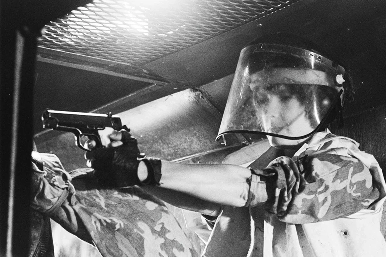 Behind the scenes still of Jenette Goldstein as Vasquez aiming a pistol in the Aliens vent set
