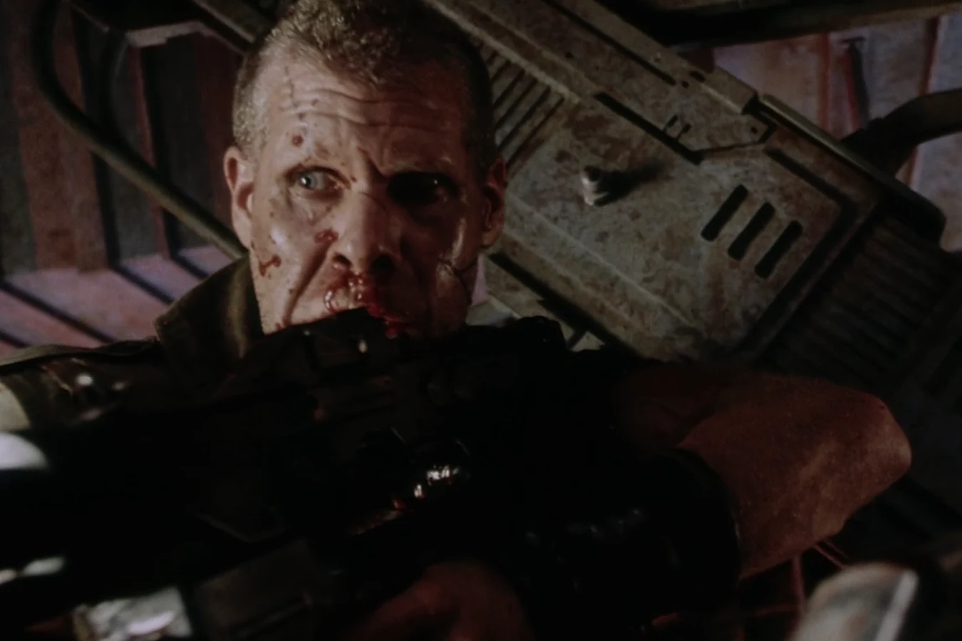 Johner with blood on his face behind a rifle in Alien: Resurrection