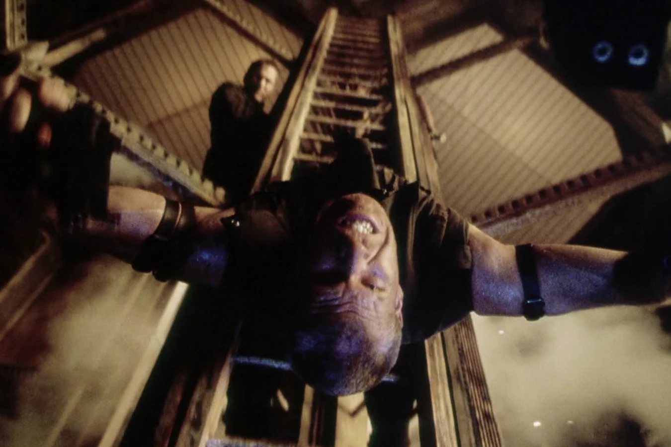 Johner hanging upside down from the ladder in the Auriga shaft
