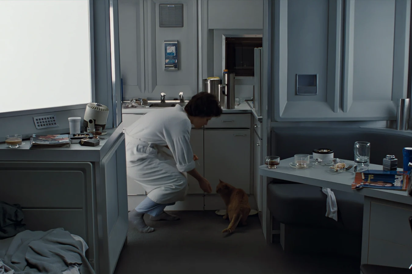 Ripley crouching to feed Jones in the galley
