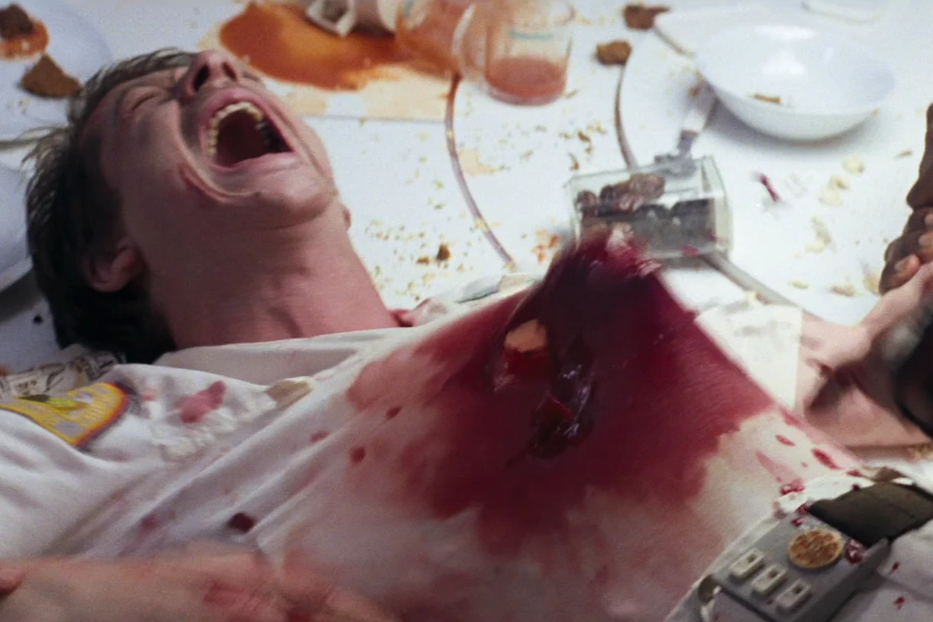 Kane lies dead on the Nostromo mess table after the Chestburster tore out