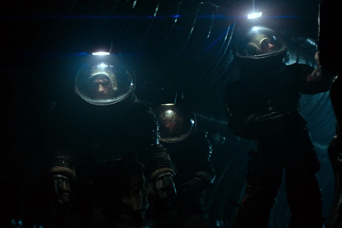 Kane, Dallas, and Lambert in helmets inside the derelict in Alien