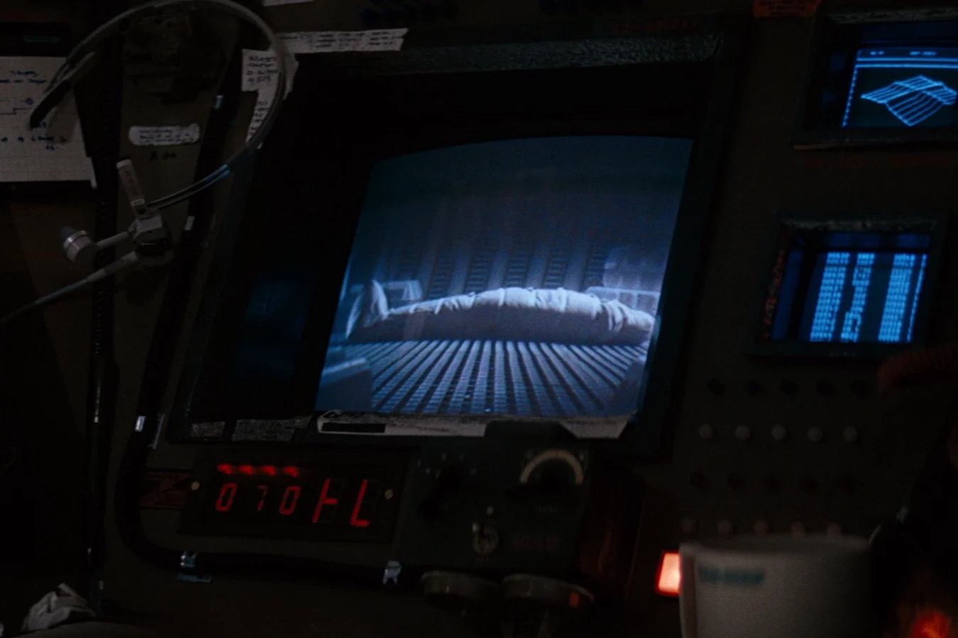 Kane's shrouded body on a Nostromo monitor during the airlock funeral in Alien