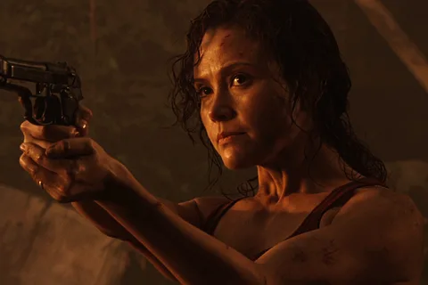 Kelly O'Brien holds a rifle under red light during the Gunnison outbreak in Aliens vs. Predator: Requiem