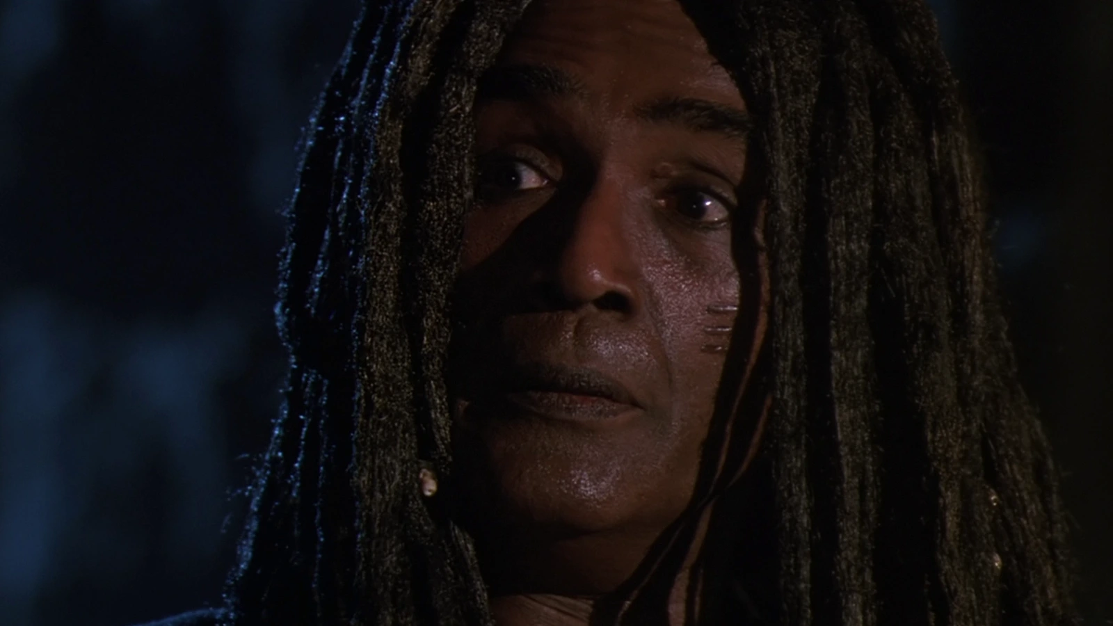 King Willie, the dreadlocked Jamaican gang leader, in a night alley in Predator 2