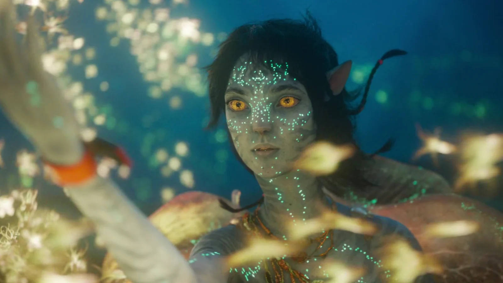 Kiri underwater surrounded by bioluminescent sea life in Avatar: The Way of Water