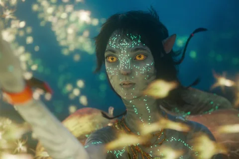 Kiri underwater surrounded by bioluminescent sea life in Avatar: The Way of Water