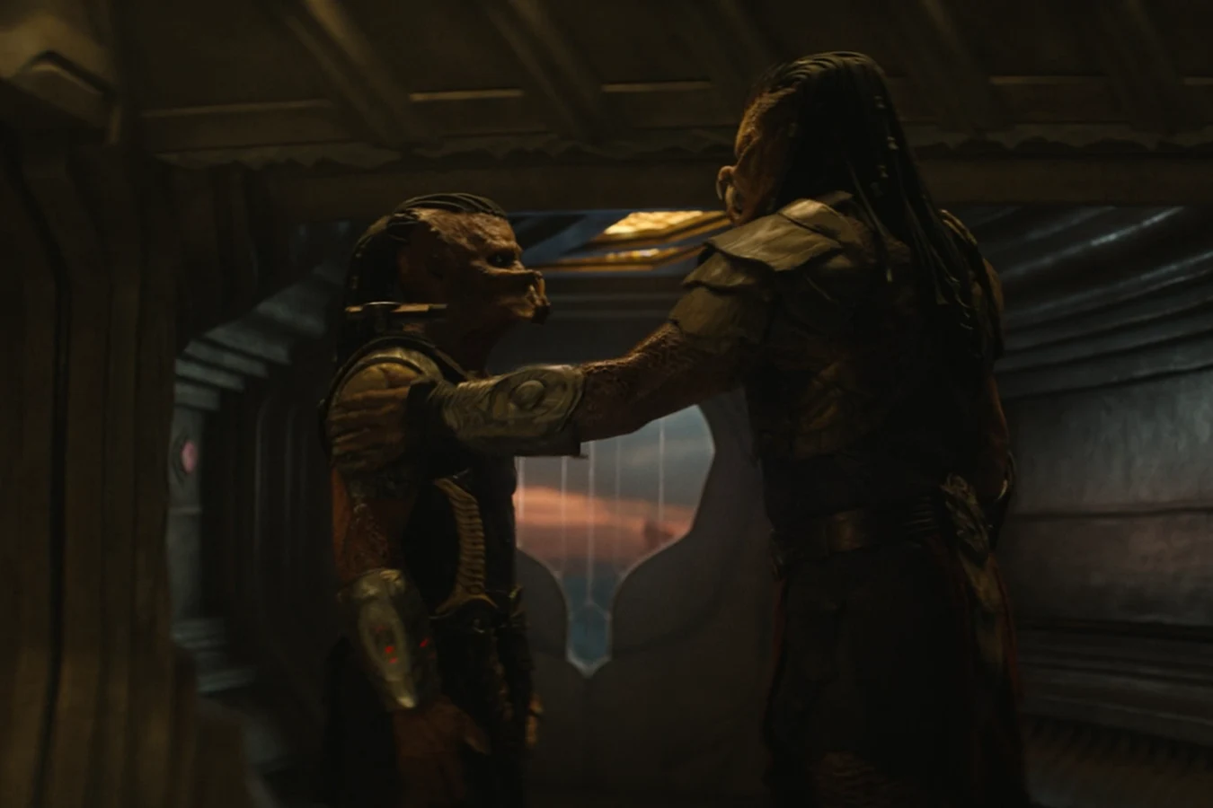 Kwei rests a hand on Dek's shoulder aboard his ship in Predator: Badlands