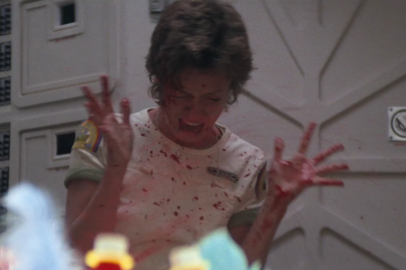 Lambert with both hands raised, covered in blood, after the chestburster in Alien