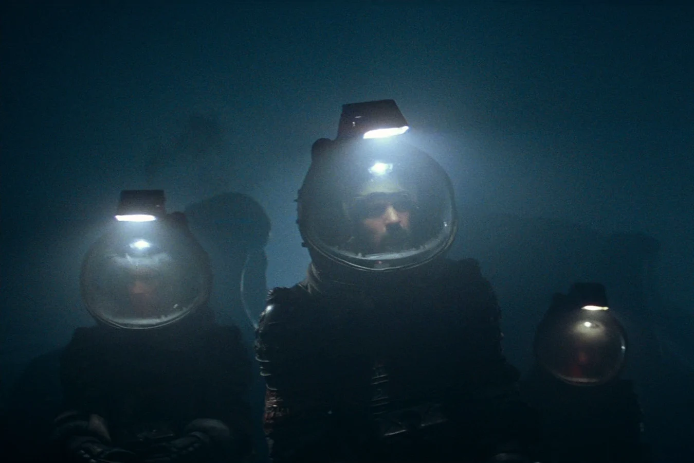 Lambert, Dallas, and Kane in lit helmets in the fog on LV-426 in Alien