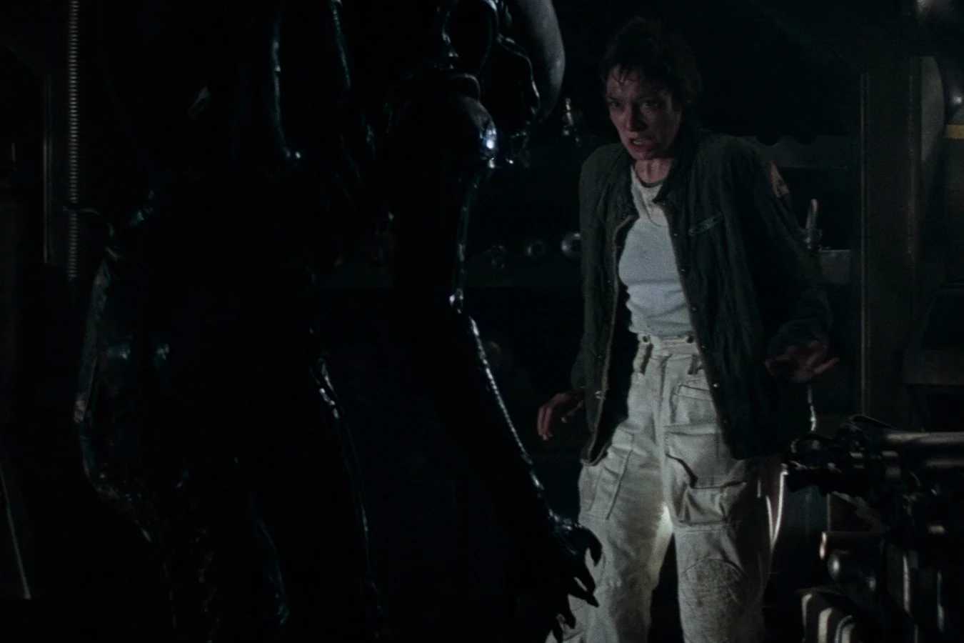 Lambert faces the adult Xenomorph in a dark Nostromo compartment in Alien