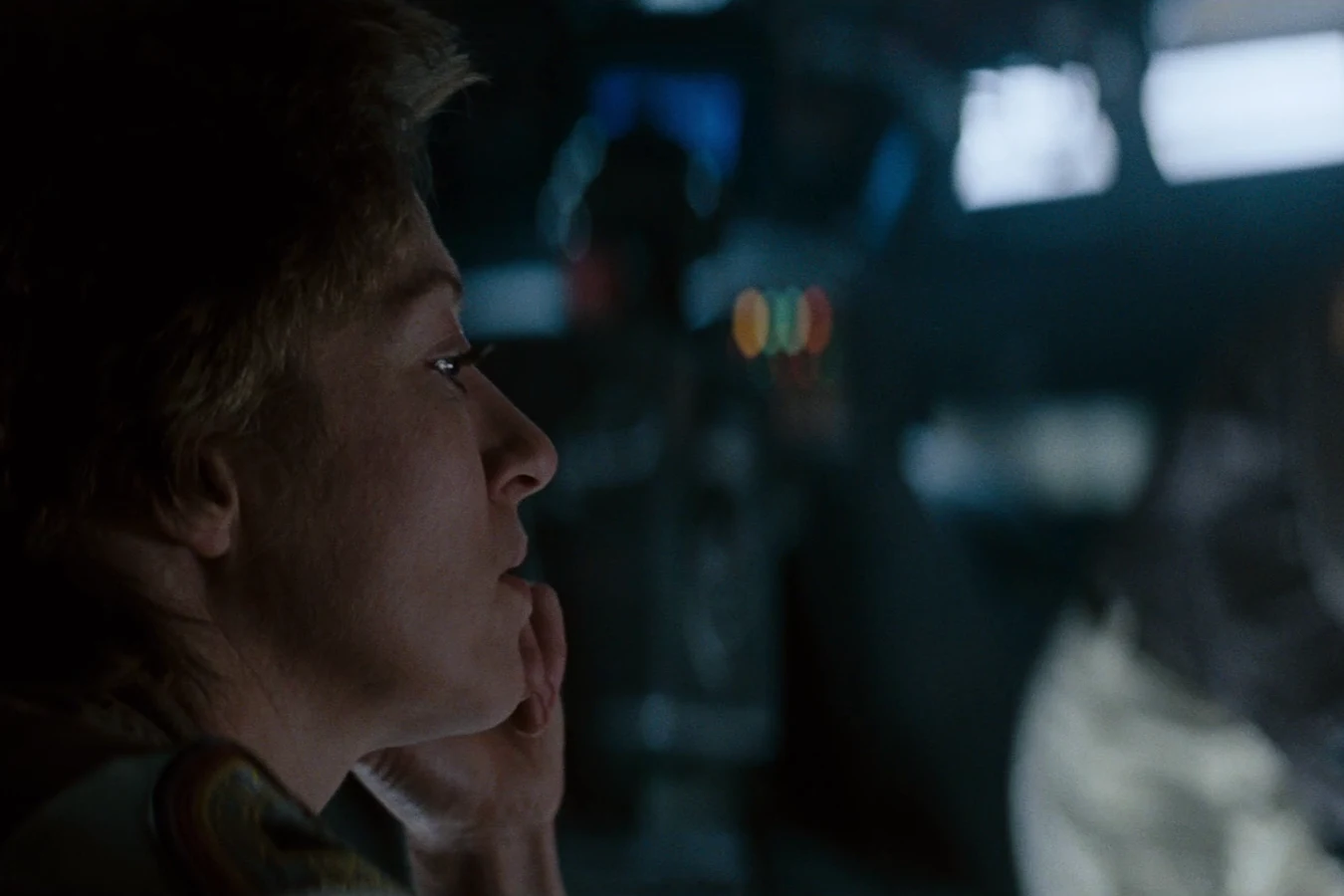 Lambert in profile on the Nostromo bridge with one hand near her mouth in Alien