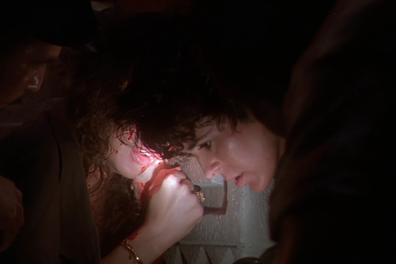 Detective Leona Cantrell inspects a crime scene with a flashlight in Predator 2