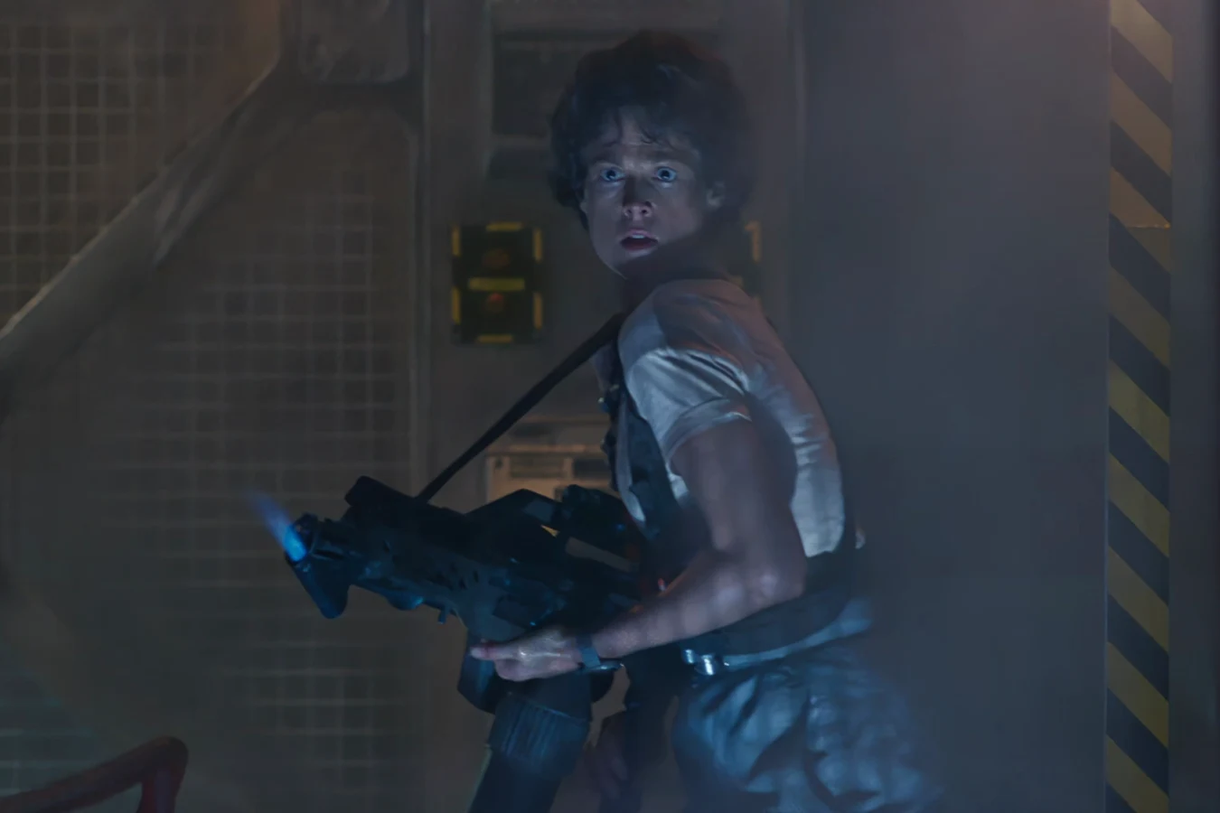 Ellen Ripley holding an M240 flamethrower with the blue pilot light lit inside Hadley's Hope