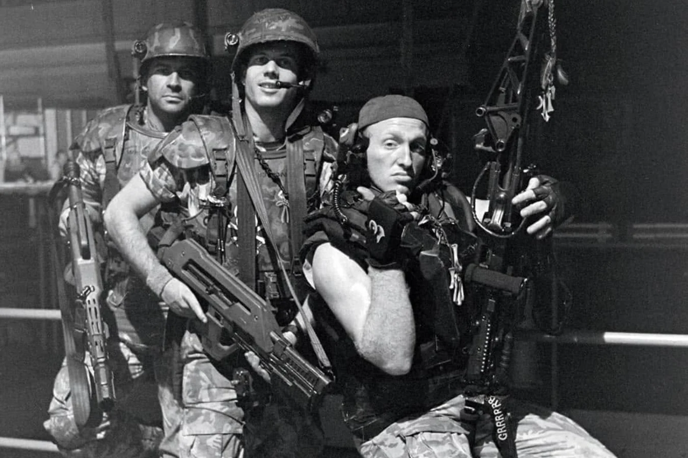 Black-and-white set photograph of Colonial Marines in M3 armor, with Drake on the M56 Smartgun and two riflemen in M10 helmets