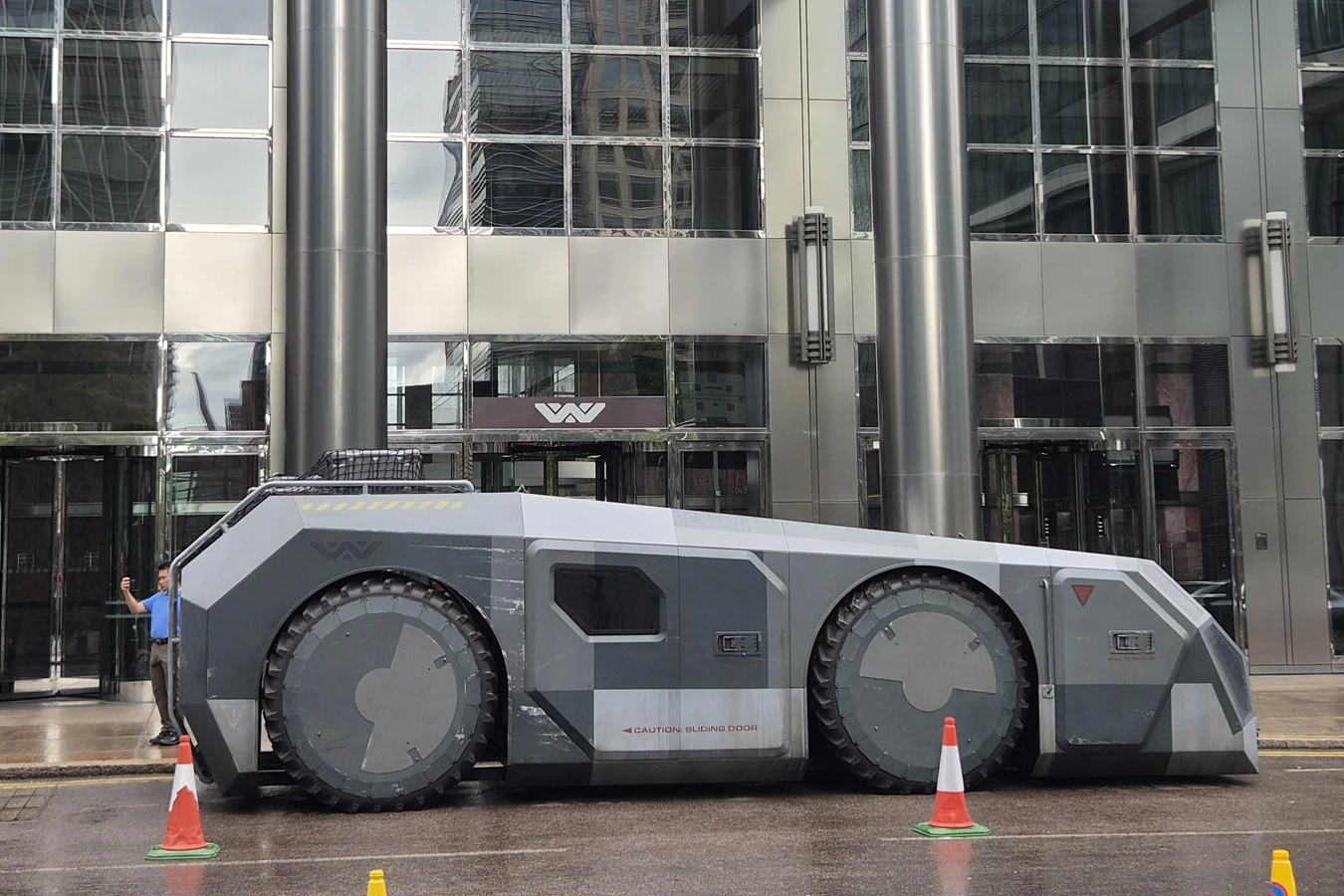 A Weyland-Yutani APC parked in front of a Company building during Alien: Earth season 2 filming