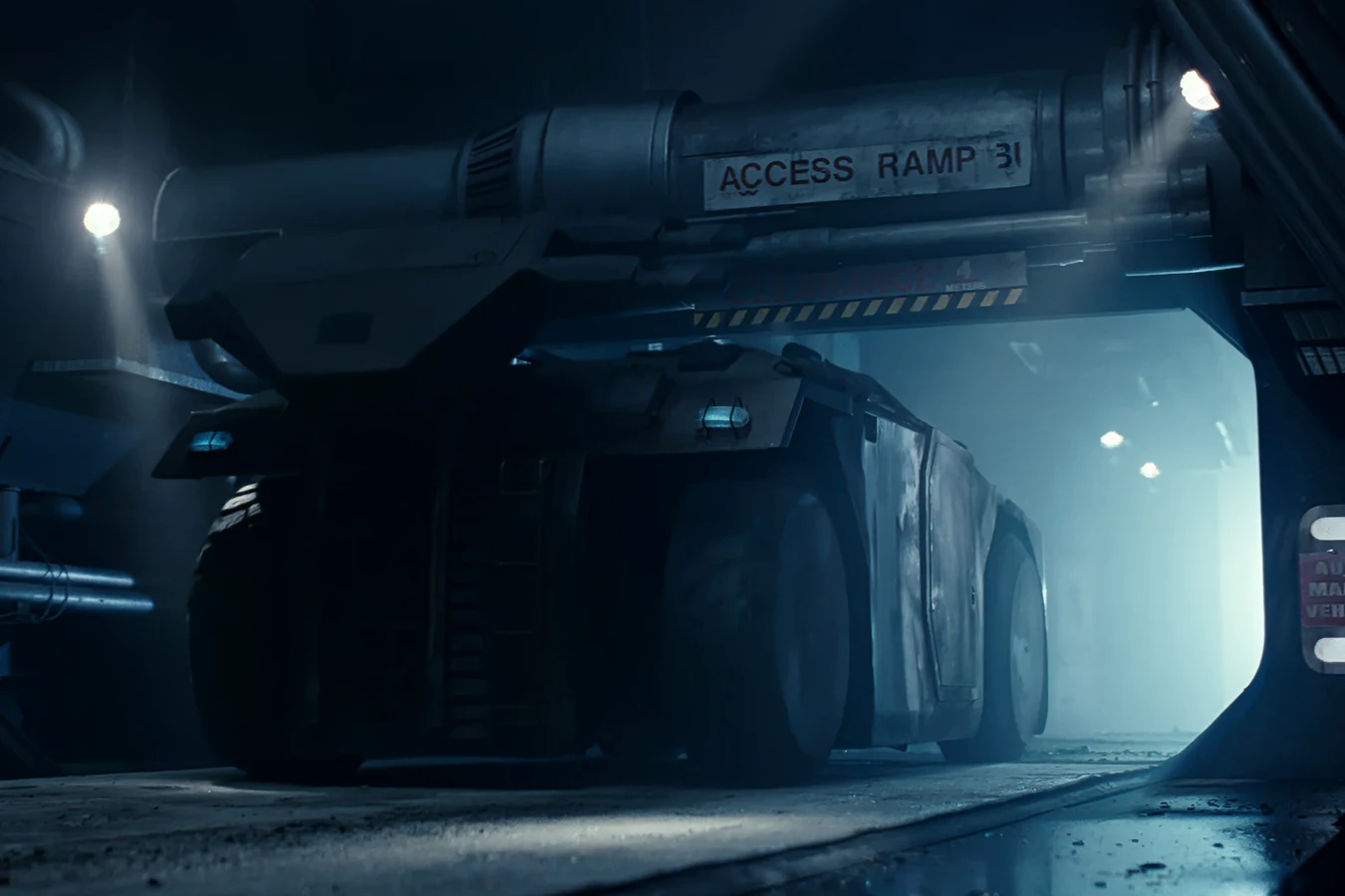 Rear three-quarter view of an M577 APC with the roof turret stowed on the rear rail under an Access Ramp 31 sign