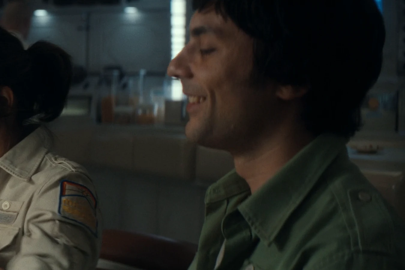 Science officer Bronski smiling beside Zaveri at the Maginot crew meal in Alien: Earth