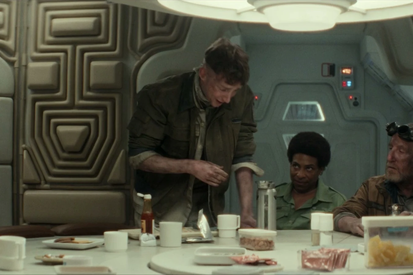 Malachite eating at the Maginot mess table during the emergency crew briefing in Alien: Earth