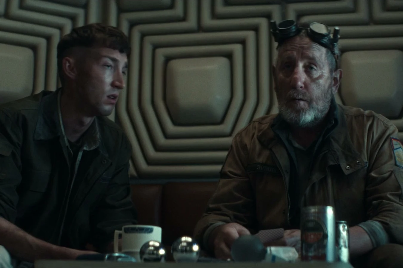 Malachite seated with Shmuel at a Maginot table during a card game in Alien: Earth