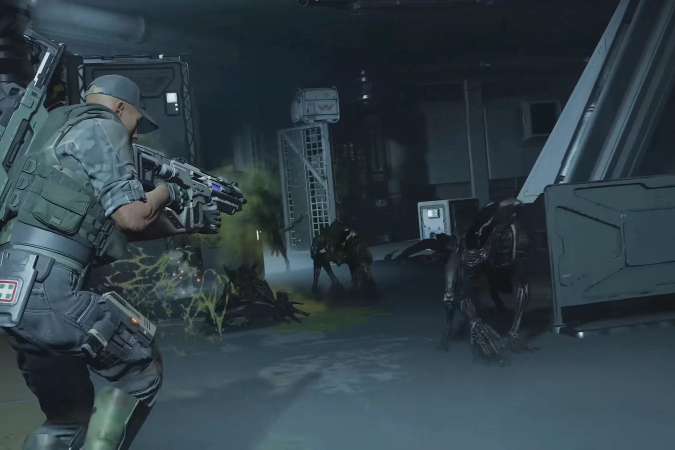 Medic Marine facing lunging Xenomorphs in a dark industrial corridor in Aliens Fireteam Elite 2