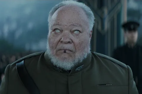 Thufir Hawat in an olive military coat, with a sapho stain on his lower lip