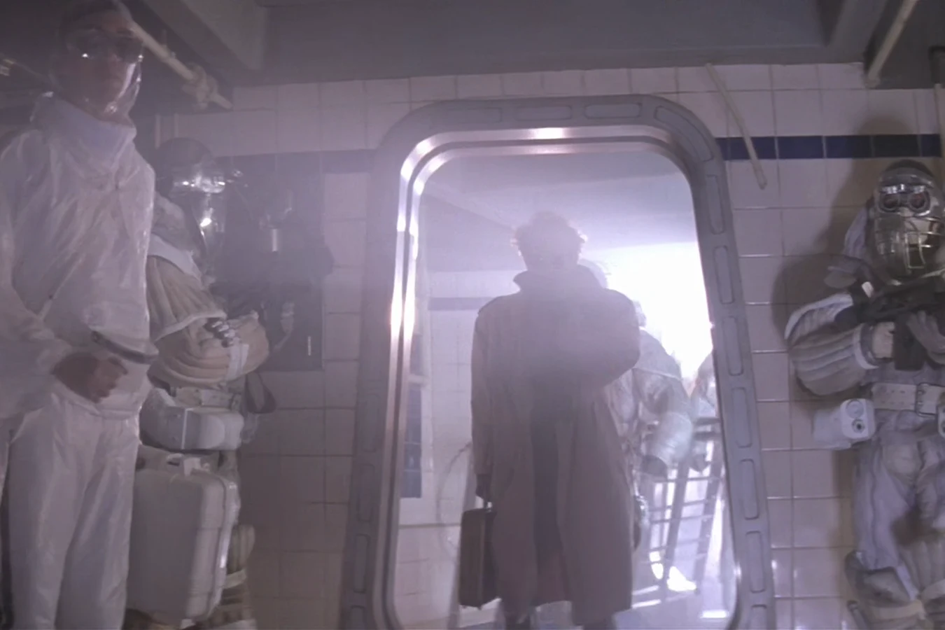 Michael Bishop arriving on Fury 161 in a coat, framed in a doorway between company troops in sealed suits