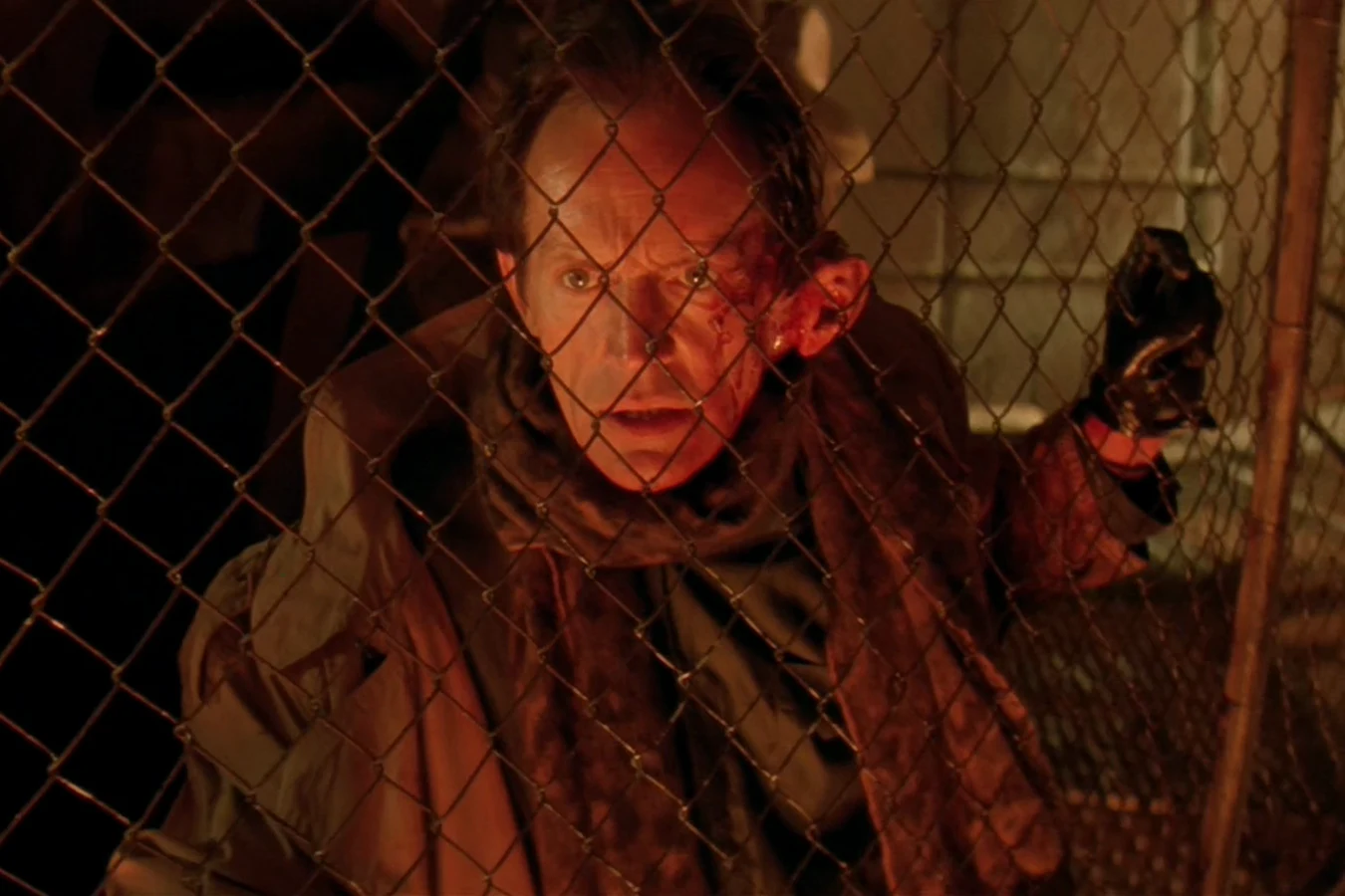 Michael Bishop behind a chain-link fence on Fury 161 with a torn, bleeding left ear