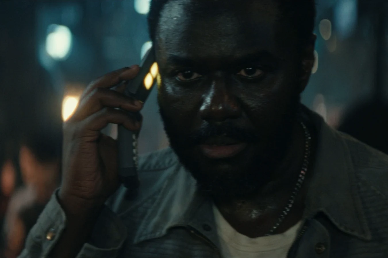 Morrow holding a phone to his ear on a crowded street in Prodigy City in Alien: Earth