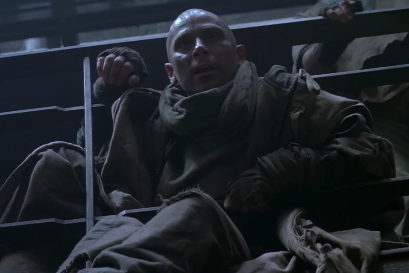 Morse in a heavy coat sitting on the Fiorina 161 assembly railing in Alien 3