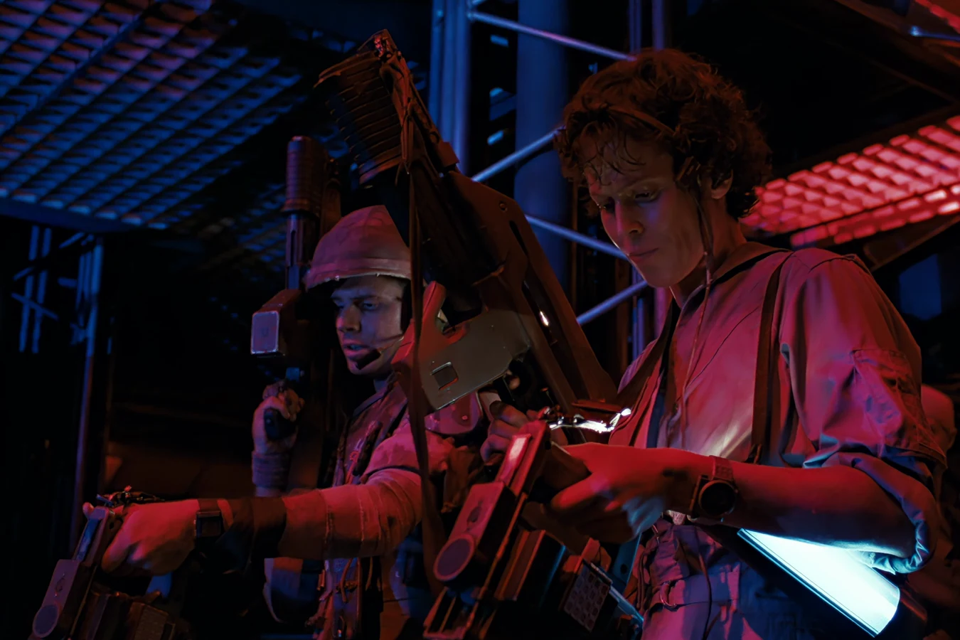 Hudson and Ripley holding M314 motion trackers in the dark colony corridors in Aliens