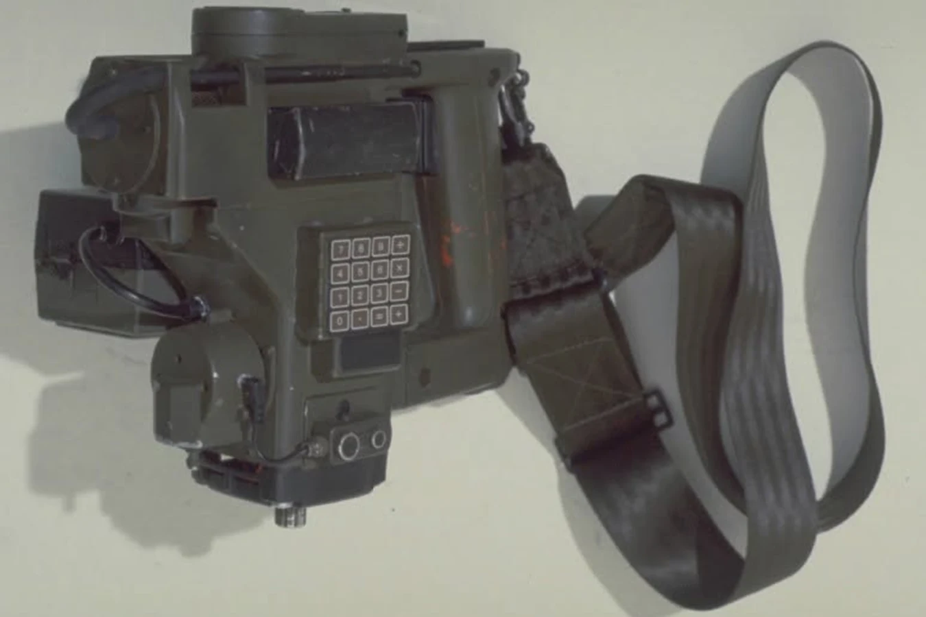 Side view of the Aliens M314 motion tracker prop with olive Kango drill body, Casio keypad, and hanging strap
