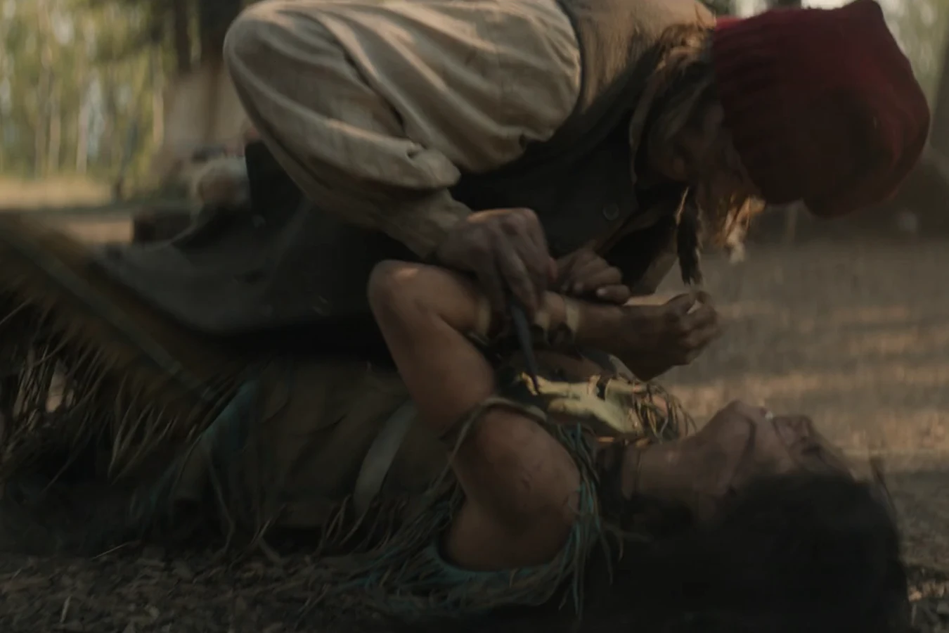A French trapper holds a knife to Naru after capturing her in Prey