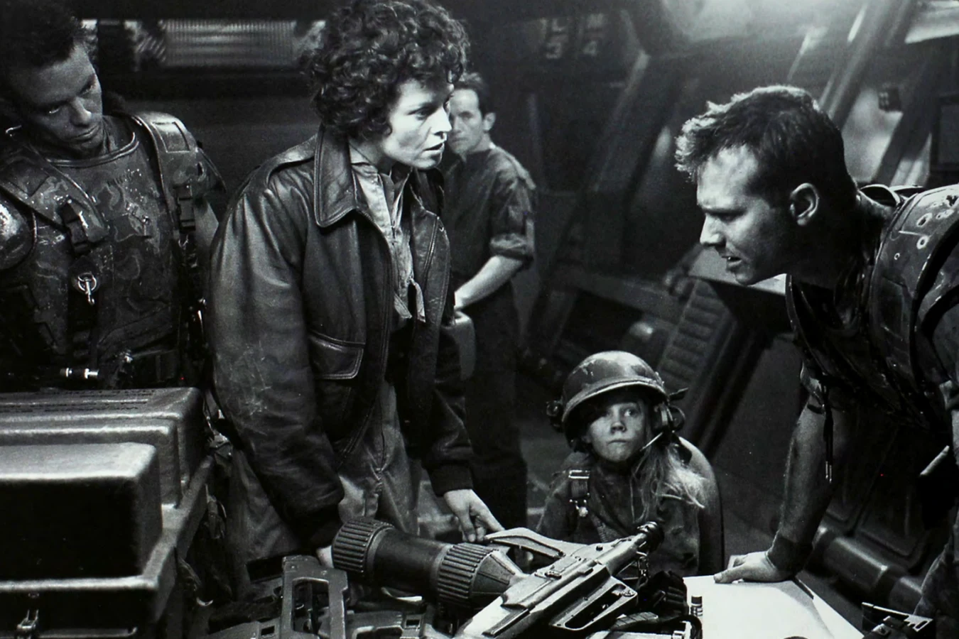Carrie Henn as Newt in a Marine helmet with Sigourney Weaver and Michael Biehn on the Aliens set