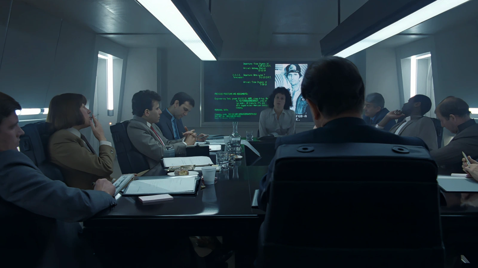Ripley's board of inquiry in Aliens with a Nostromo crew dossier on the screen