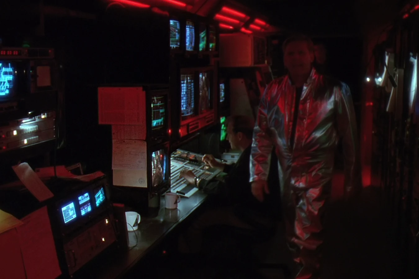 Peter Keyes in a silver suit inside the OWLF trailer in Predator 2