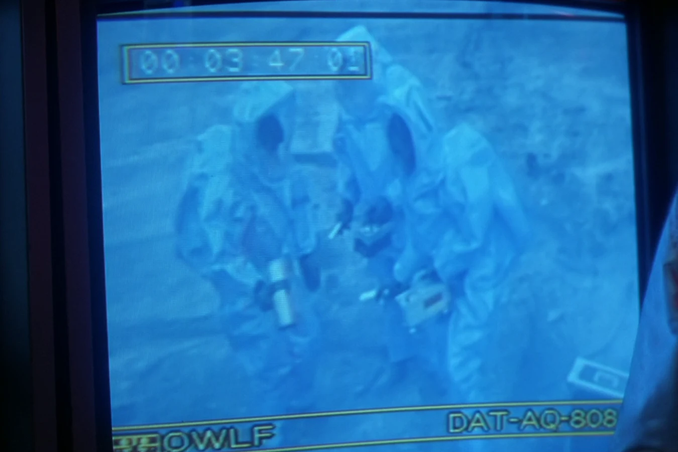 OWLF survey team in radiation suits at the Jungle Hunter blast crater, shown on Keyes's trailer monitor in Predator 2