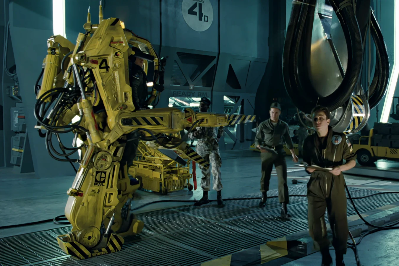 Rear view of a Caterpillar P-5000 Power Loader in the Sulaco hangar, showing the PWL marking, hydraulic legs, and Ready Room doorway