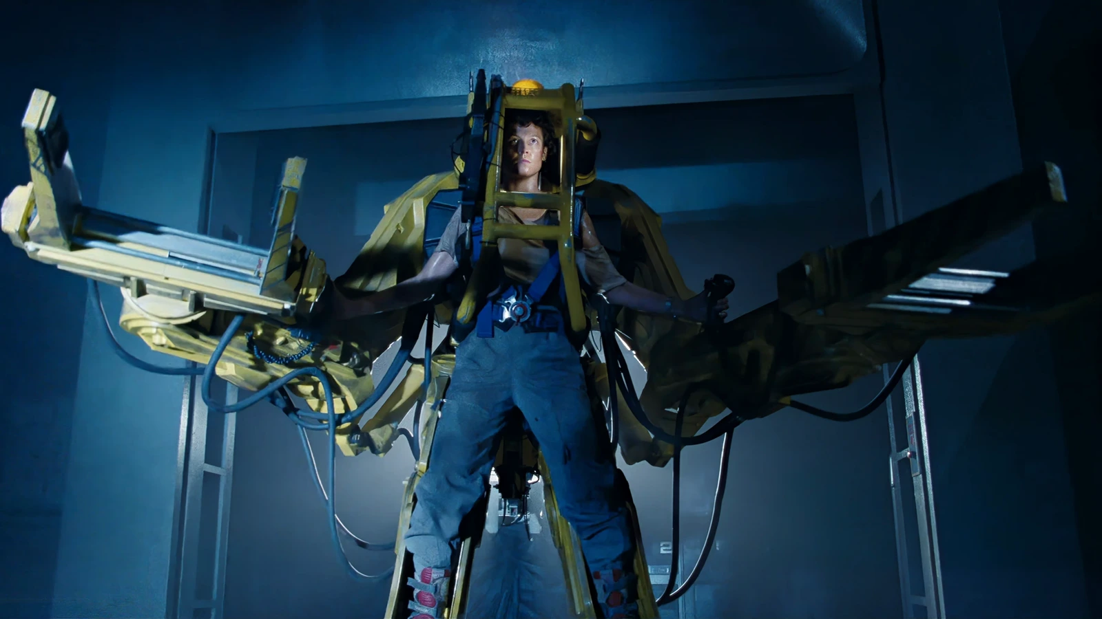 Ellen Ripley strapped into a Caterpillar P-5000 Power Loader in the Sulaco cargo bay in Aliens
