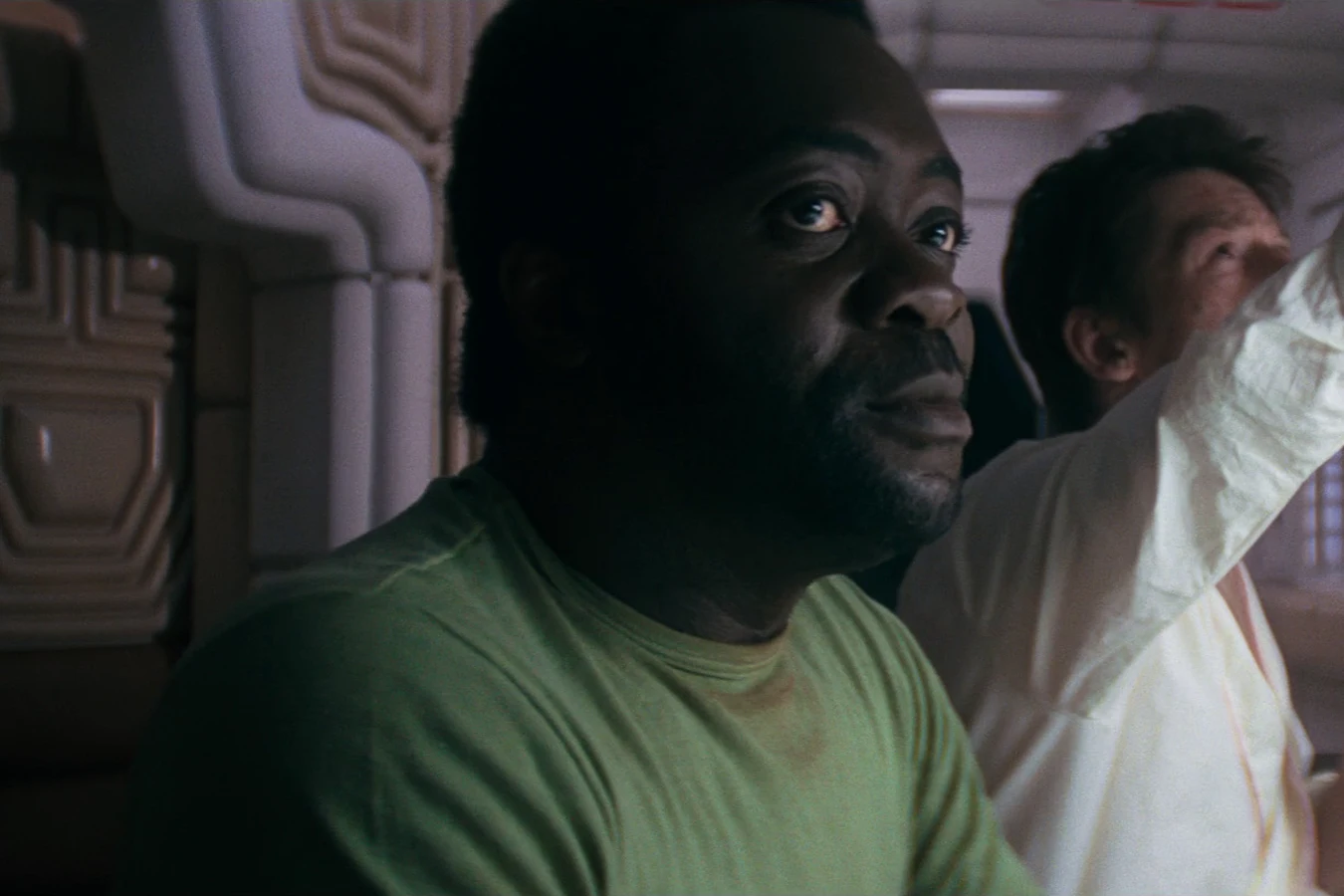 Parker in a green shirt in the Nostromo mess, with Dallas stretching behind him in Alien