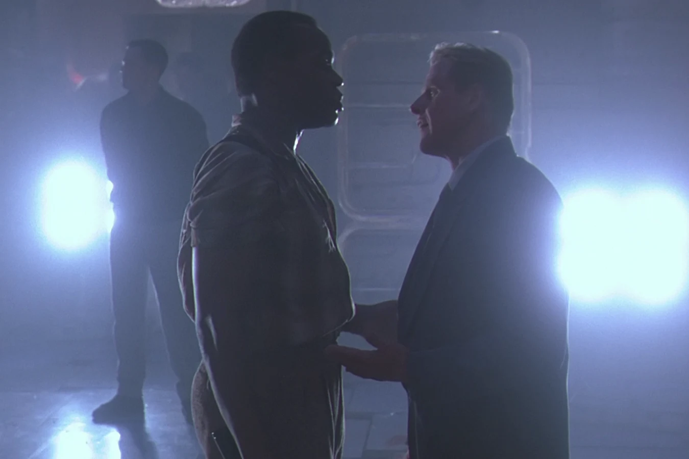 Peter Keyes greets Lieutenant Harrigan at Ramon Vega's penthouse in Predator 2