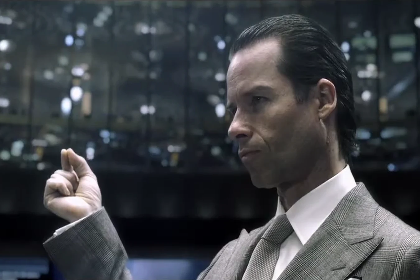 Young Peter Weyland in a grey suit raises a hand during the 2023 TED talk