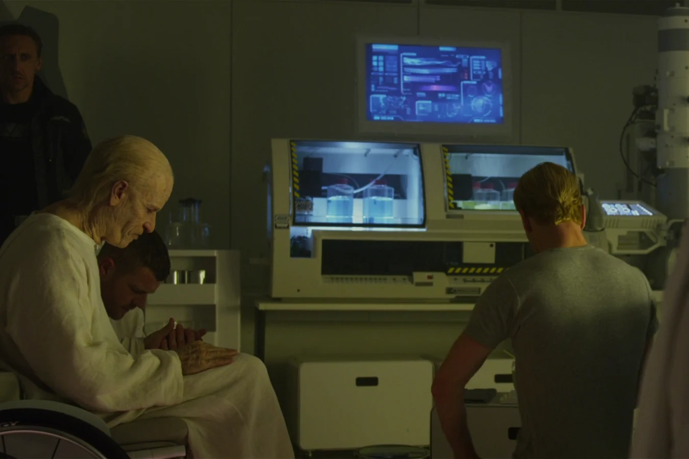 Elderly Peter Weyland in a white gown, in a wheelchair in the Prometheus medical bay