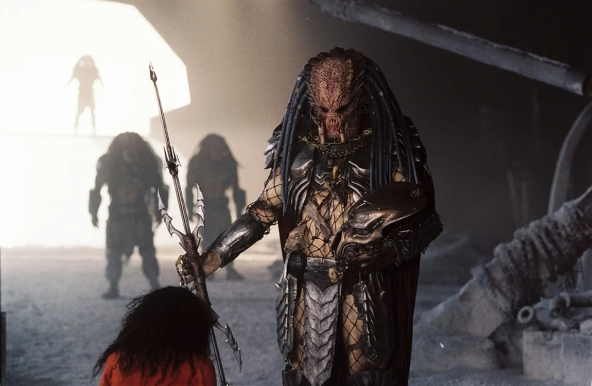 The Elder Predator from AvP with a red cape