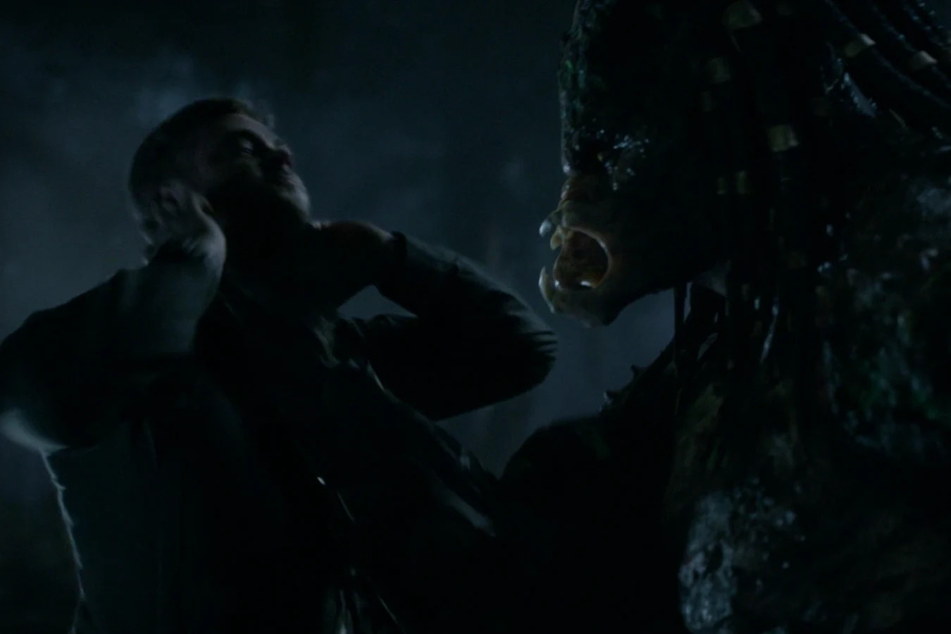 The Upgrade Predator gripping Quinn McKenna by the throat in the woods